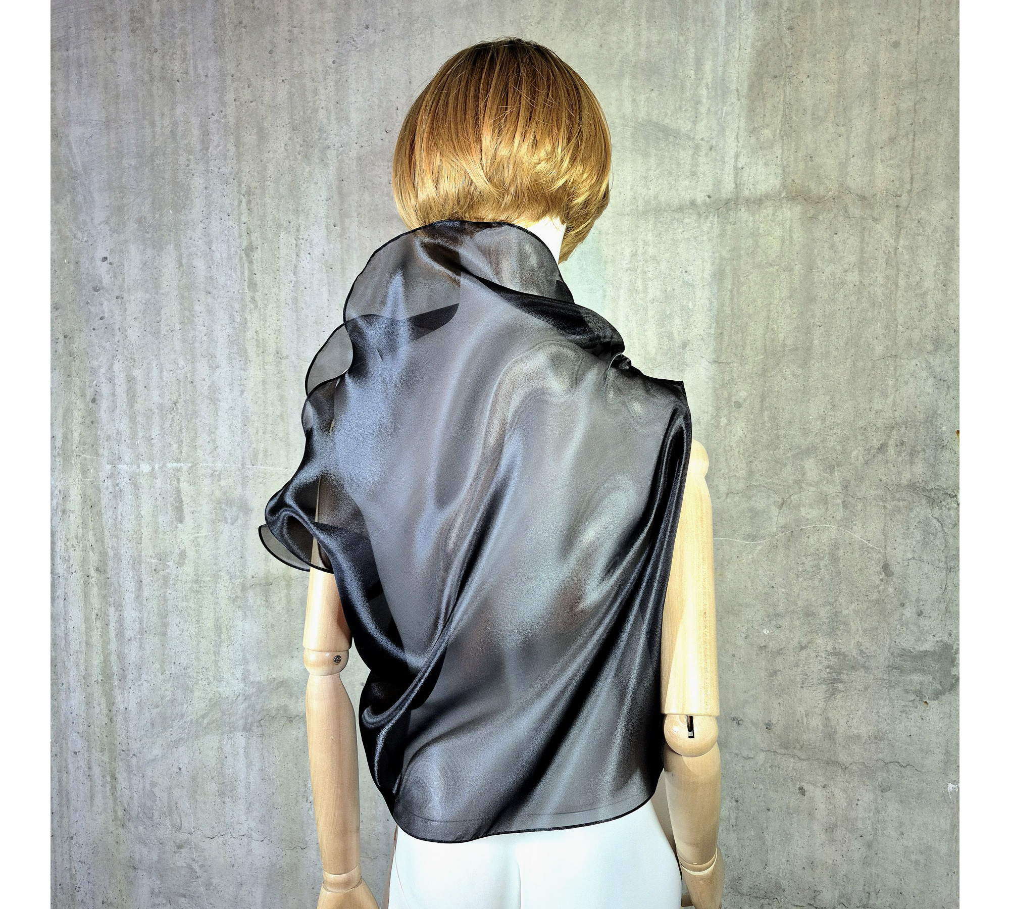 Black asymmetrical blouse a high neck, made of translucent organza.