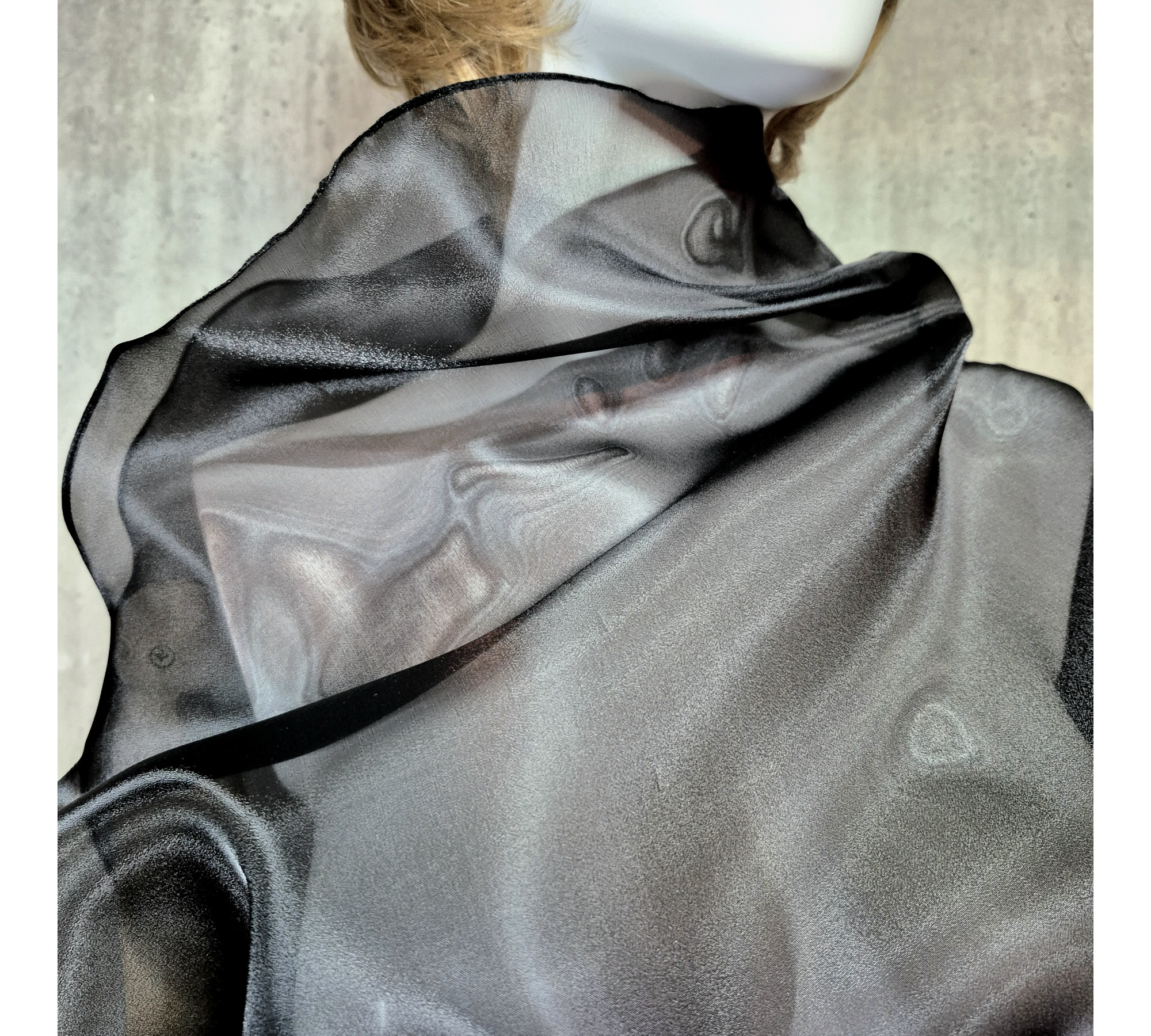 Black asymmetrical blouse a high neck, made of translucent organza.